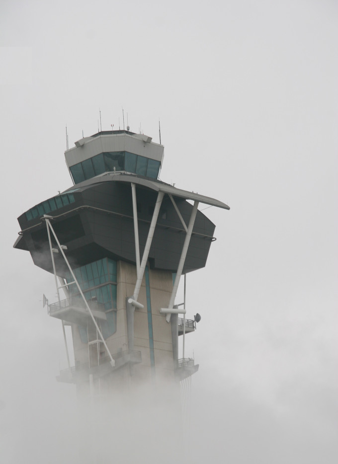 Airport control tower in morning smog or fog
