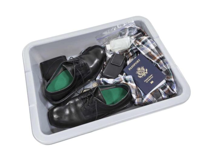 Passengers who fly commercial airlines need to place their belongings and shoes in an airport security tray.