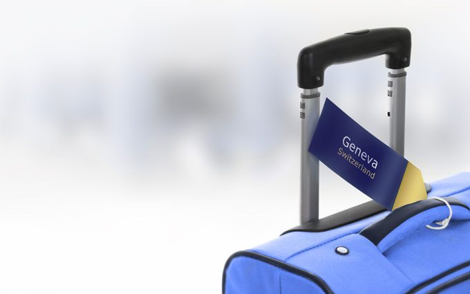  Geneva, Switzerland. Blue suitcase with label at airport