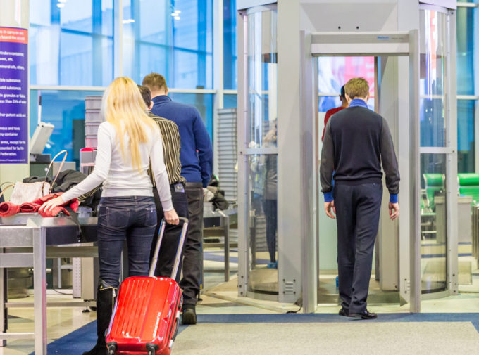 Traveler going through full body scan at a commercial airport security checkpont. 