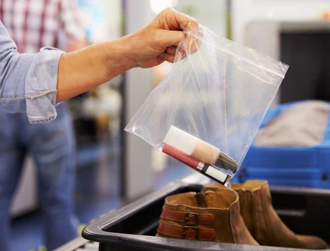 Passenger places liquids in clear zip lock bag for security.